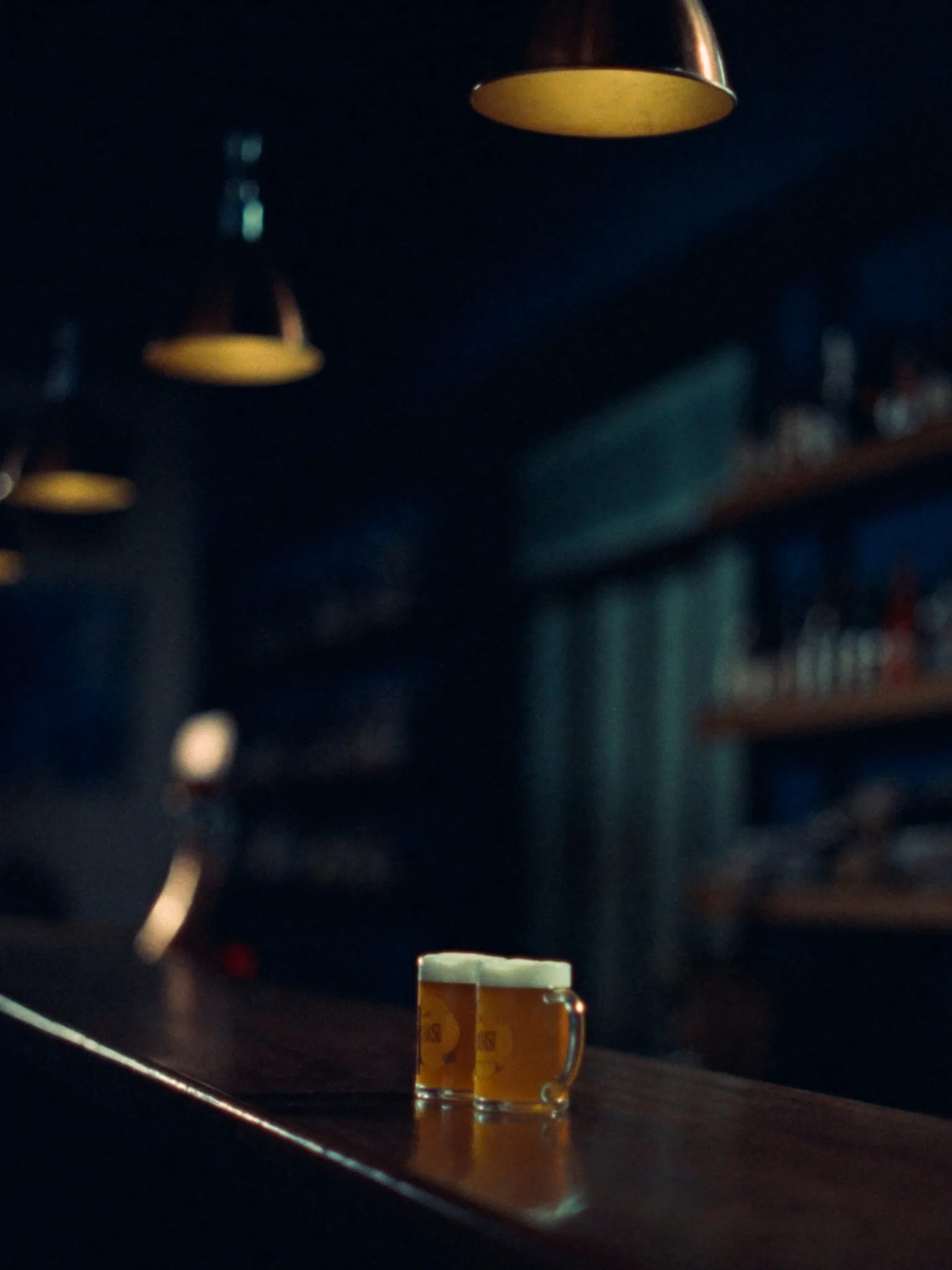 Detalle de la barra de madera de Taberna Skyline con tarros de cerveza artesanal